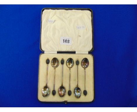 A boxed set of enamel and Silver spoons