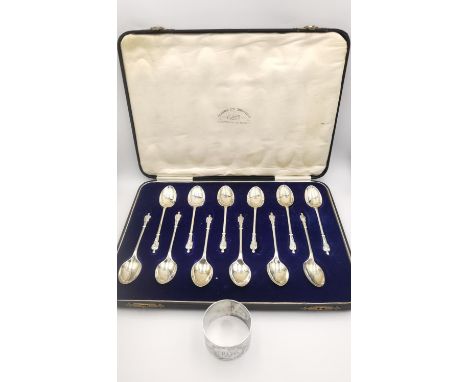 A leather cased set of twelve Art Deco apostle design silver tea spoons by Gladwin Ltd (1930, Sheffield) and an engraved napk