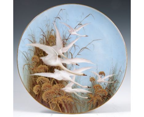 A Royal Worcester wall plate, decorated with six Swans in flight and foliage to a powder blue ground, by C.H.C Baldwyn, marke