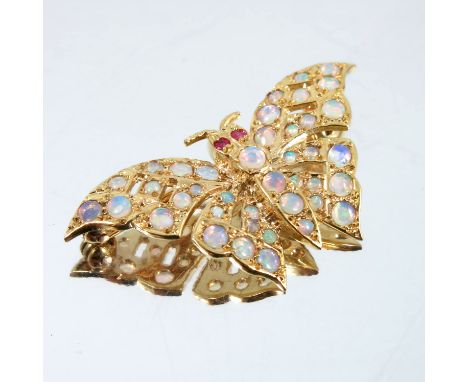 A 9 carat gold opal set butterfly brooch, set throughout with small round cabochons, having stone set eyes, 4cm across, 5.5g 