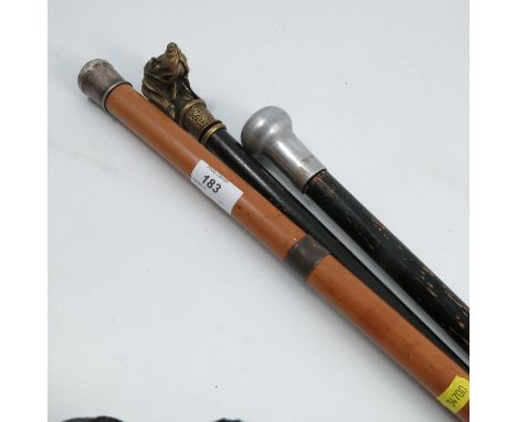 A Victorian walking stick, with ebonised shaft, the brass handle formed as a dogs head, together with two other walking stick