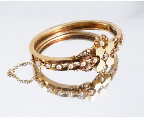 A late Victorian diamond and pearl hinged gold bangle, the central panel star set with an old brilliant cut of approximately 