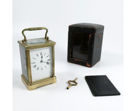A brass cased carriage clock, with striking movement, white dial with Roman numerals, height including handle 6.75ins, togeth