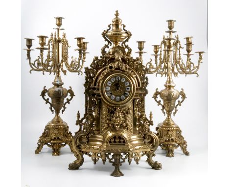 A German F.H.S brass clock garniture, with striking movement, the gilt metal dial with Roman numerals, the case with urn, scr