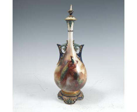 A Royal Worcester Hadley’s covered vase, decorated with a peacock and peahen on a branch with pine cones by W E Jarman, havin
