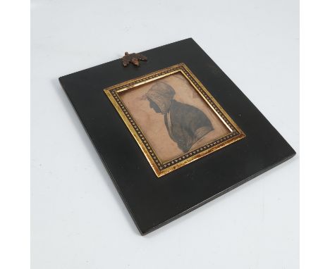 An early 19th century framed portrait silhouette, by Wakins, of a woman wearing a bonnet, with gilt metl slip and black frame
