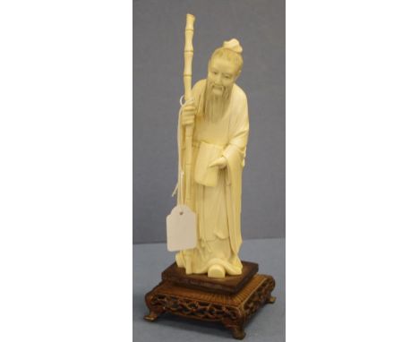 Antique Chinese ivory sage figure on stand man carrying a staff, on carved wood stand. Export of this item would be subject t