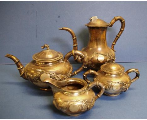 Four piece Chinese export silver teaset comprising teapot, hot water pot, creamer & sugar bowl, with dragon in relief decorat