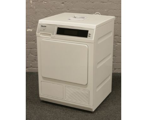 A Miele Supertronic tumble dryer with instruction manual.