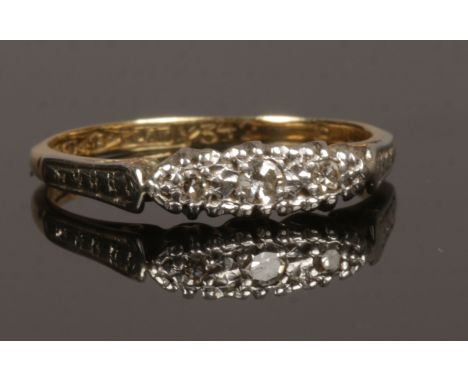 An 18ct gold and platinum three stone diamond ring, size K, 2.3 grams.