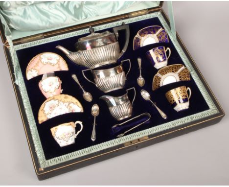 An Edwardian travelling salesman's silver and china teaset. With four Copeland Spode coffee cups and saucers, each decorated 