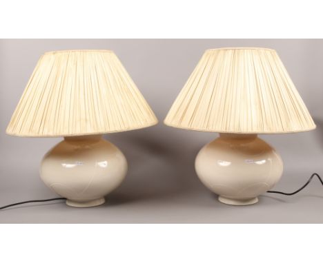 A pair of large ceramic cream coloured table lamps.
