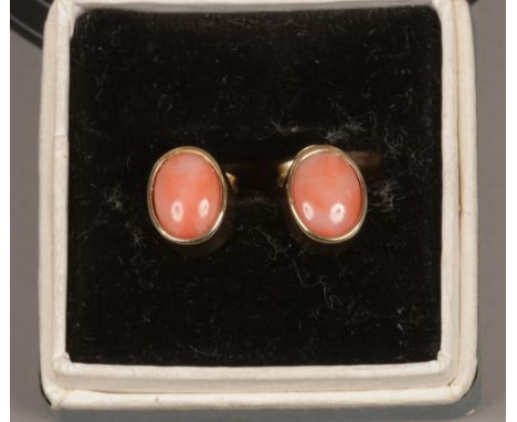 A pair of vintage 9ct gold ear studs each with one ovoid coral stone, having post and butterfly backs.