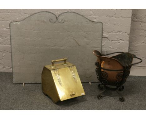 A brass coal scuttle with shovel along with a copper and wrought iron examples and an iron firescreen.