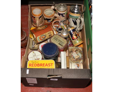 A box of vintage tins and German pottery steins.