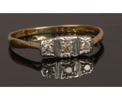 An Art Deco 18ct gold and platinum three stone diamond ring, size O, 1.66 grams.