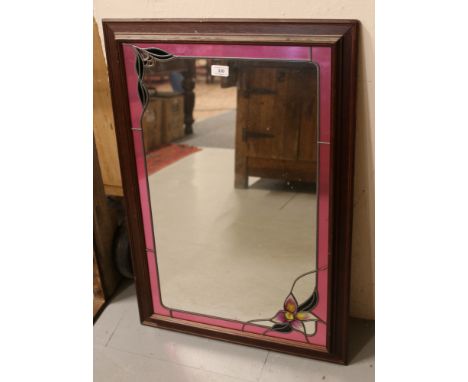 A wooden framed stained glass effect mirror.