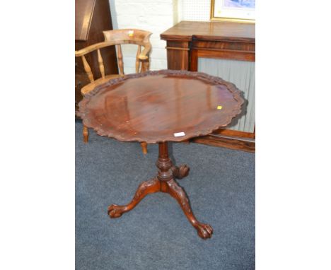 An 18th century-style mahogany tripod table, with pie-crust tilt top, fluted column on leaf carved cabriole legs, talon and b