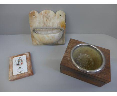 A holy water font, a part of a collection box and a marble mounted tile 