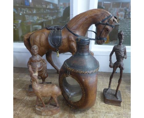 A Liberty style leather model of a horse, three carved wooden figures and a leather glass flask 