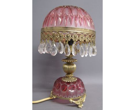 Cranberry glass Bohemian table lamp with gilded metal feet and stem, cut glass decorated cover and droplets