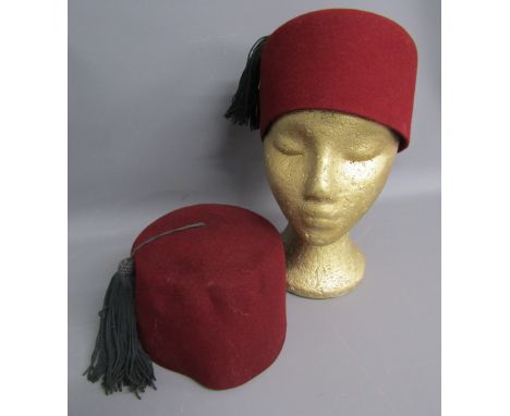 Two Tommy Cooper fez hats - one stamped inside H&amp;P 7 1/8 1955 with war department broad arrow and one worn. Provenance: T