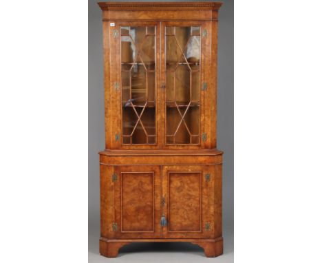 A good quality burr walnut tall corner cabinet in the 19th century style, the upper part fitted two shaped shelves enclosed b