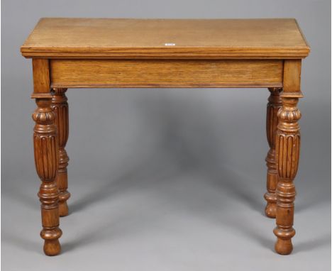 A 19th century oak card table inset green baize to the rectangular fold-over top, &amp; on four carved &amp; turned tapered l