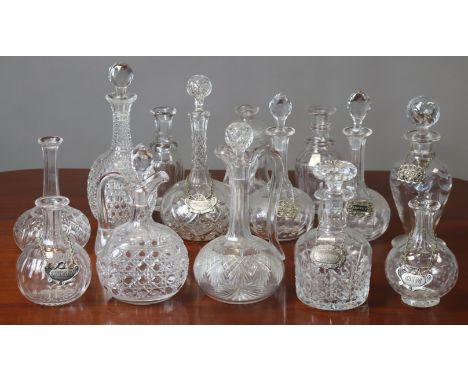 Fourteen various clear glass decanters (six lacking stoppers, seven with plated decanter labels).