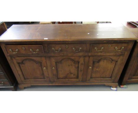 Reproduction 18th century style Welsh oak dresser base with three cock beaded drawers over three arched fielded panel cupboar