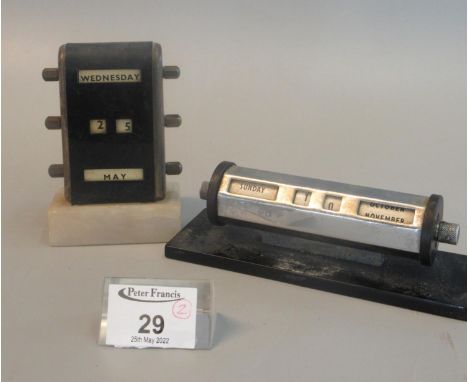 Two art deco design desk calendars, upright and horizontal cylindrical. (2) (B.P. 21% + VAT) The item is not silver.  11x7 cm