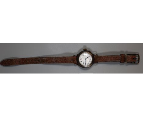 Early 20th century gun metal small size keyless wrist watch with enamel face, having Arabic numerals on leather strap.(B.P. 2