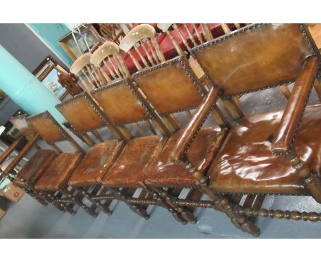 A set of six 17th Century style oak dining chairs with leather upholstery and brass stud work - all standing on bobbin turned