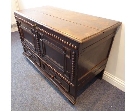 A good late 17th century oak mule chest; the planked moulded top opening on original hinges and with candle box to the right 
