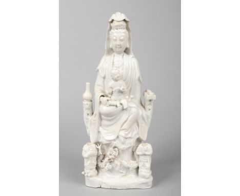 An 18th century Chinese blanc de chine statue of Guanyin and acolytes. Surrounded by precious objects, seated upon a throne o