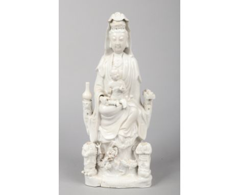 An 18th century Chinese blanc de chine statue of Guanyin and acolytes. Surrounded by precious objects, seated upon a throne o