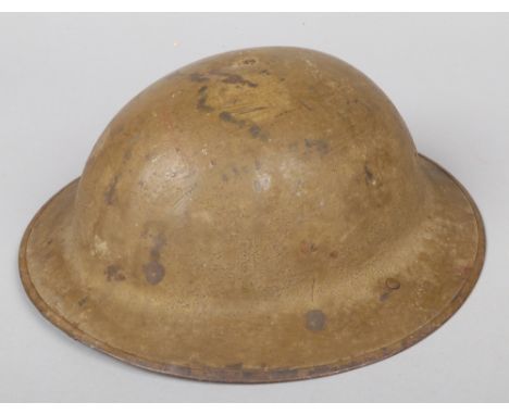 A World War I British Mk 1 Brodie Helmet. Stamped FS No. 167. With folded rim, liner and leather chin strap.  Retaining some 