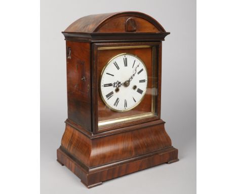 A 19th century German simulated rosewood cuckoo clock. With dome top, enamel dial having Roman numeral markers and raised on 