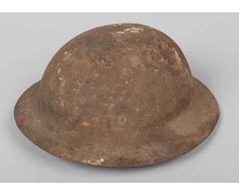 A World War I model A War Office pattern Brodie helmet. With raw edge and having leather chin strap.  Still retaining much of
