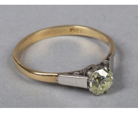 An 18 carat white and yellow gold solitaire diamond ring. Set with a round cut diamond approximately 0.75ct, 2.56 grams, size