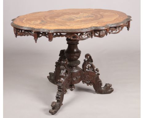 A 19th century Black Forest mahogany centre table. With marquetry panels depicting hunting scenes and raised on a carved trip