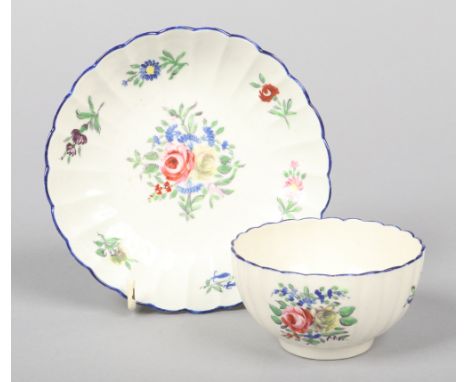 A Caughley fluted teabowl and saucer. Painted in overglaze enamels with rose bouquets and scattered sprigs under wet blue rim