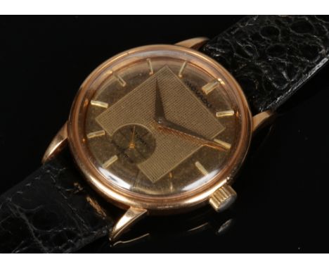 A gentleman's 18 carat gold cased Movado Automatic Gentleman wristwatch. With gold dial having baton markers, engine turned e