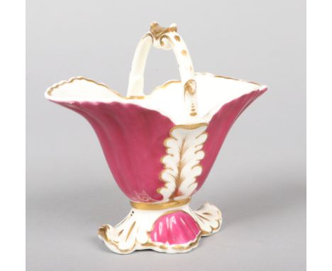 An uncommon Rockingham helmet-shaped basket with arched handle, acanthus leaves moulded to the reeded tapering body and raise