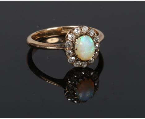 An 18 carat gold opal and diamond halo cluster ring. Gross weight 3.6 grams, size Q.  