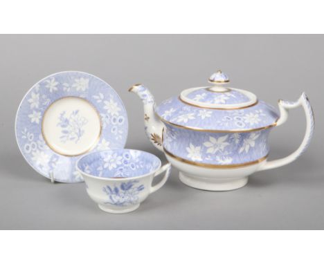 A Rockingham teapot and cover and a teacup and saucer with figure 7 handle. Printed in underglaze blue with a woven ground re