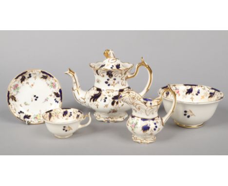 A Rockingham part tea service with single spur handles. Moulded with scrolling foliage, having wet blue and gilt borders and 