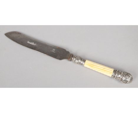 A Victorian bread knife. With carved ivory grip and silver mounts. Blade marked Alpha and inscribed Bread Knife. Assayed Lond