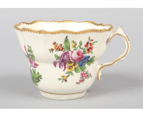 A Caughley caudle cup of scalloped ogee form and with scrolling handle. Painted in coloured enamels with exotic birds and flo