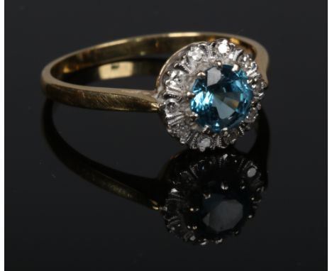 An 18 carat gold blue zircon and diamond halo cluster ring. 3.49 grams, size R.  